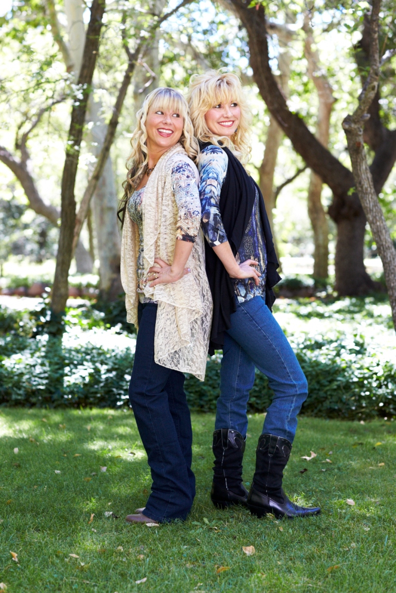 Allie Ollie Models Standing Back to Back in Shawl Dawl, Three Quarter Length Sleeve Tee, and Daniell Jeans